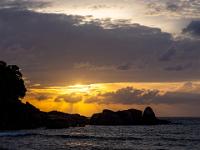 Sonnenstrahlen und glitzernder Anse Takamaka Strand am Abend - Mahé